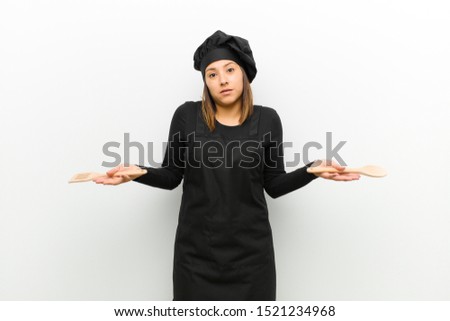 cook woman feeling puzzled and confused, unsure about the correct answer or decision, trying to make a choice against white background