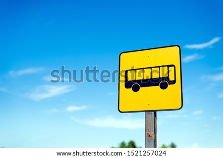 closeup bus stop sign with a blue sky background