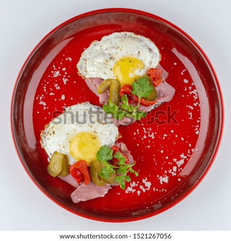 Traditional breakfast with sunny-side up breakfast, greens and crispy bacon isolated on white flat lay