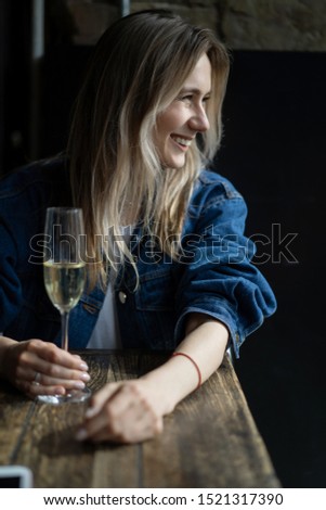 Young beautiful woman in a cafe, a woman drinking champagne in a cafe and talking.