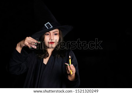 Portrait of beautiful asian woman wear witch costume on black background,Thailand people,Halloween festival concept,Horror scene