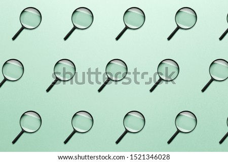 Trendy pattern made with Magnifying glass on bright light mint background. Concept information search. Minimal style with colorful paper backdrop. Colorful photo. Minimal creative concept. Neo mint