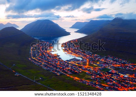 Fantastic aerial evening cityscape of Klaksvik town with glowing streets and fjord, Bordoy island, Faroe islands, Denmark. Landscape photography