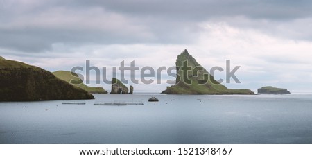 Dramatic panoramical view on Drangarnir and Tindholmur sea stacks in Atlantic ocean, Faroe Islands. Landscape photography
