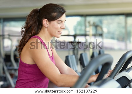 Young woman adjusting the treadmill