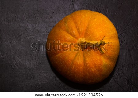 Pumpkins on black table. Halloween background with pumpkin. Copy space. Top view