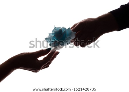 The hand of a young man gives a flower to an elderly woman - silhouette, decoration