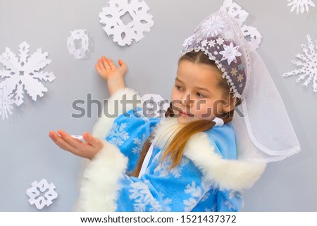 Snow Maiden plays with big snowflakes. Winter and New Year.