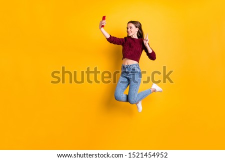 Full size photo of lovely girl making photo v-signs wearing burgundy pullover isolated over yellow background
