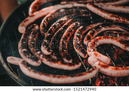 Closeup picture of smoking grill with sausages on it