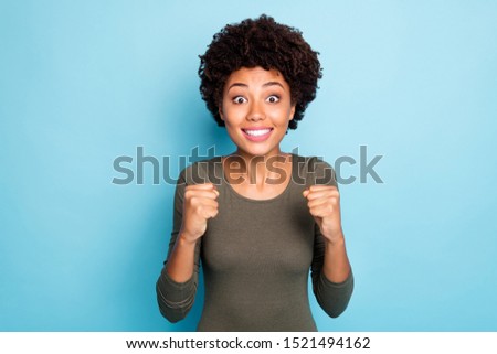 Portrait of funny funky girl raise fists watch football match please want her team win hope they score goal wear green clothes isolated over blue color background