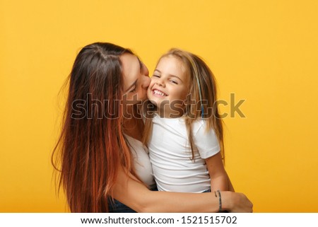 Woman in light clothes have fun with cute child baby girl 4-5 years old. Mommy little kid daughter isolated on yellow background studio portrait. Mother's Day love family parenthood childhood concept