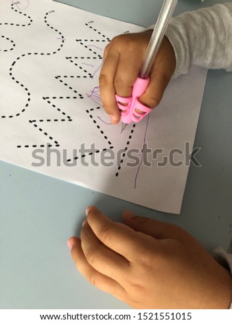 the child learns to write. child draws patterns in a notebook. 