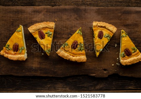 slices of homemade pumpkin pie on wooden background