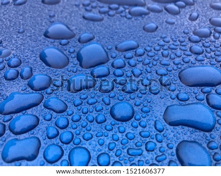 Photo of a blue metallic car finish with water beading on top,