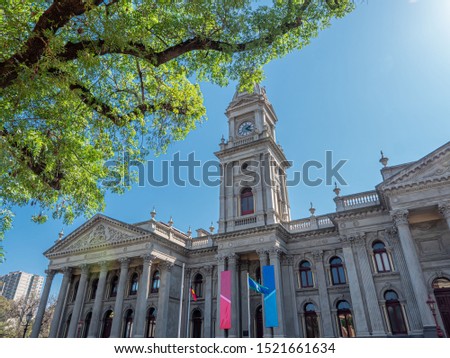 Fitzroy town hall with a clock tower, a tree, and blue sky. Fitzroy, Melbourne, Victoria, Australia. Nice day of spring. Yarra city council. Royalty-Free Stock Photo #1521661634