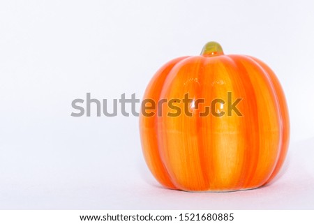 Bright orange festive pumpkin ornament on an isolated white background for fall thanksgiving and halloween season.