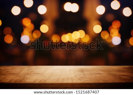background of wooden table in front of abstract blurred restaurant lights Royalty-Free Stock Photo #1521687407