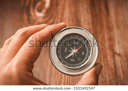 Metallic compass on wooden background 