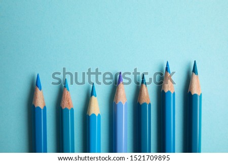Flat lay composition with color pencils on light blue background