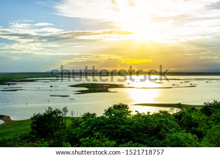 Beautiful sunset sky on the river, Beautiful silhouette picture of sunset above the sea, Warm orange sky with sunset light shine through clouds