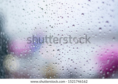 Travel in bad weather conditions concept background with water drops on window with blurred view on colorful airplanes