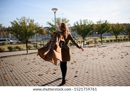 Autumn portrait of a red-haired girl on the street