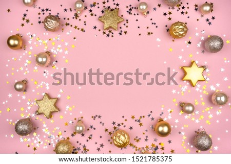 Festive pink background with gold and silver stars and Christmas balls. Flat lay, top view. Copy space for your text.