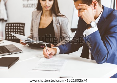 Caucasian man signing contract, hand putting signature on official document, biracial clients customers couple make purchase or sign prenuptial agreement concept