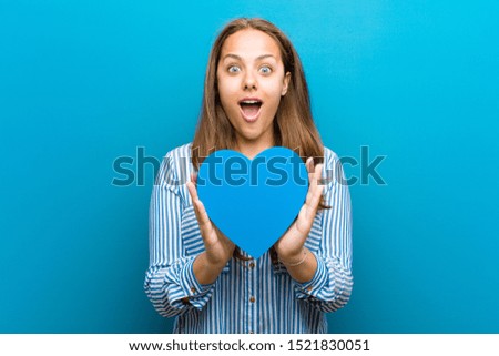 young woman with a heart shape against blue background