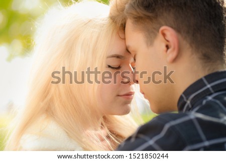 A man affectionately call looks at woman, guy and girl are worth close, touching the tips noses. The concept of first teenage love and first kiss. Boy and girl, couple. Intimacy, honesty, trust