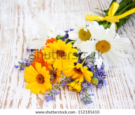 bouquet of calendula, daisy and lavender  flowers on a wooden background