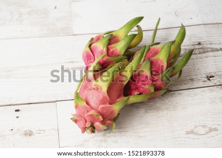 Dragon fruit or pitaya with slice isolated on wood background, exotic tropical diet nutrition