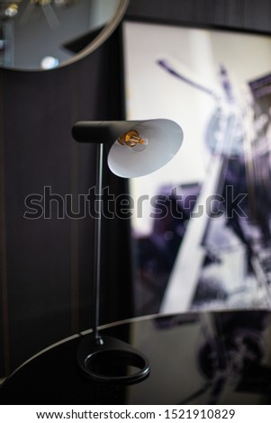 Beautiful minimal black and white table lamb standing on a glass table