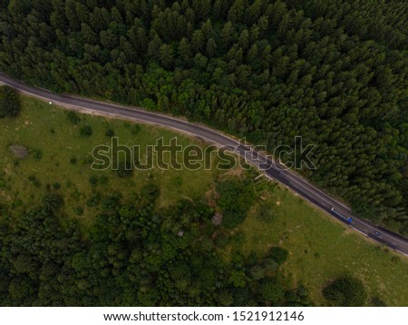 Aerial view over mountain road going through forest landscape. Transylvania, Romania
