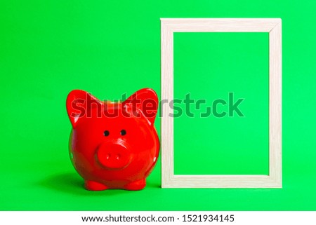 red pig piggy bank with a light wooden frame on a green background
