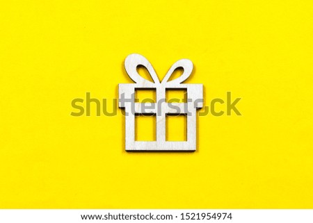 Decorative gift box made of plywood on a yellow background. Christmas and event decorative elements