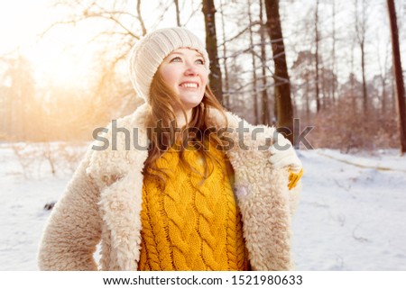beautiful cheerful young woman in winter forest