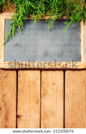 Vintage chalkboard on wooden table with pine tree branches