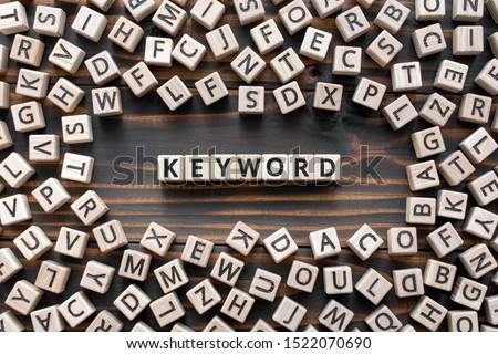 Keyword - word from wooden blocks with letters, search information that contains that word keyword concept, random letters around, top view on wooden background Royalty-Free Stock Photo #1522070690