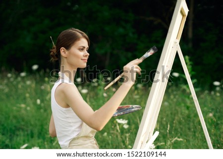 beautiful artist woman paints an easel