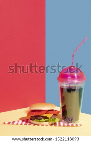 Arrangement with cheeseburger and tasty juice 