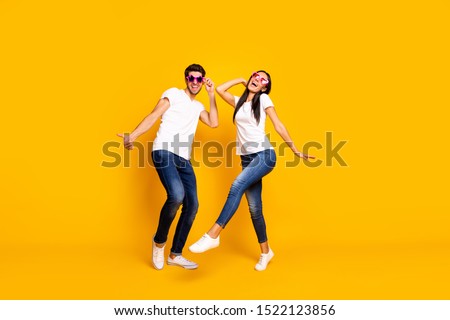 Full body photo of two people dancing at first season theme party wear cool specs and casual clothes isolated yellow color background
