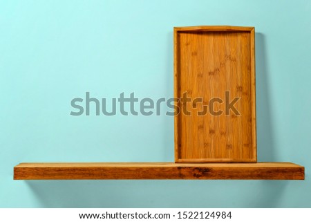 Background of kitchen shelf and free space for your product. Wall of blue color and shadows. 