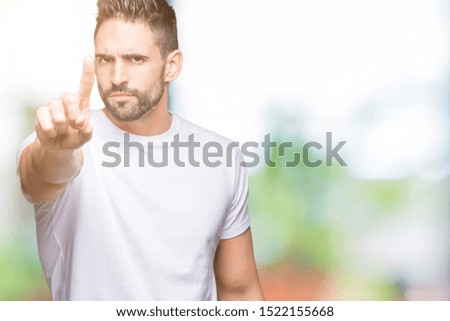 Handsome man wearing white t-shirt over outdoors background Pointing with finger up and angry expression