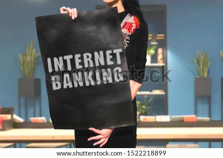 The phrase " Internet marketing " drawn on a black carton banner in woman hands. Woman in black dress and with black hair holds a cardboard with an inscription. IT, office, computer science, digital