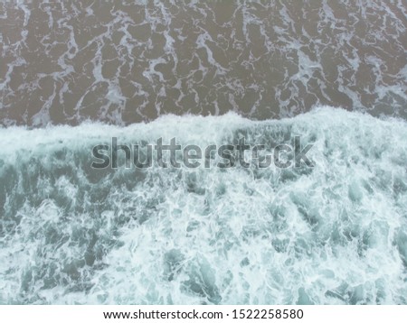 Abstract texture of water with waves and sand. Top view of turquoise water as background, Ocean, sea, lake.
