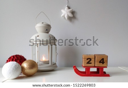 white Christmas picture with calendar cubes and candle lamp