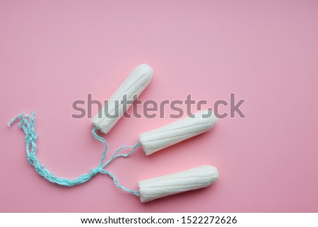 Medical female tampons on a pink background. White tampon for women. Menstruation, means of protection.
