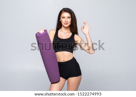 Young attractive woman holding a yoga mat. Isolated on white